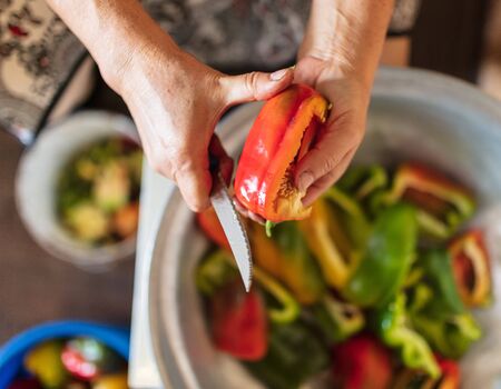 A woman cuts a paprika with a knife.の写真素材