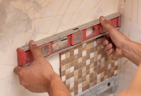Worker glues tiles on the wall.の写真素材