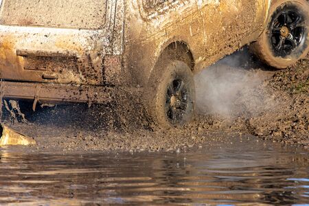 SUV wheel stalled in mud and water.