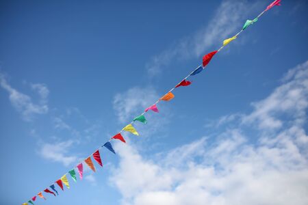 Multi-colored flags on a background of blue sky.の写真素材