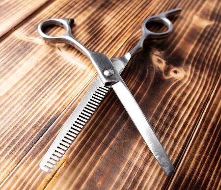 Scissors for haircuts on a wooden background.の写真素材