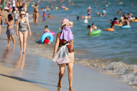 Sanya, Hainan Island, China - January 8, 2020: Woman with a closed face on the beach in Dadonghai Bay.のeditorial素材