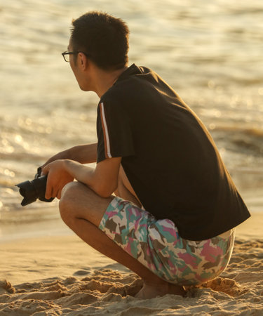Sanya, Hainan Island, China - January 8, 2020: A man photographs on the beach in Dadonghai Bay.のeditorial素材