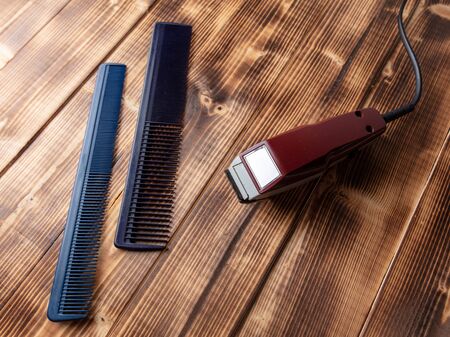 Combs and clipper on a wooden background.の写真素材