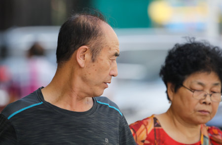 Sanya, Hainan Island, China - January 14, 2020: Chinese grandfather on a city street.のeditorial素材
