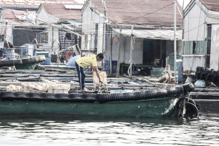 Sanya, Hainan Island, China - January 14, 2020: Fisherman on a boat in the South China Sea.のeditorial素材