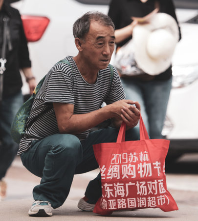Sanya, Hainan Island, China - January 14, 2020: Chinese grandfather on a city street.のeditorial素材