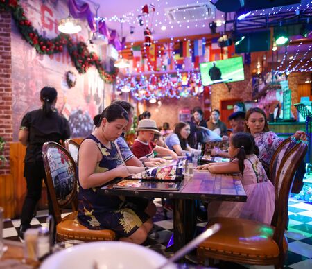 Sanya, Hainan Island, China - January 10, 2020: A Chinese family dines in a restaurant.のeditorial素材