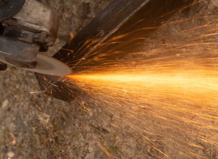 Sparks from sawing metal at a construction site.