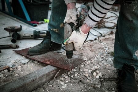 A worker cuts metal at a construction site.の写真素材