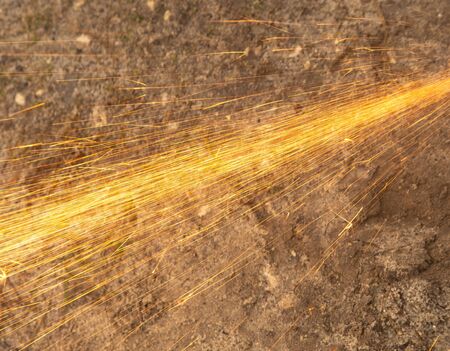 Sparks from sawing metal at a construction site.