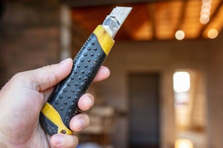 Construction knife on a wooden board. Building a house.の写真素材
