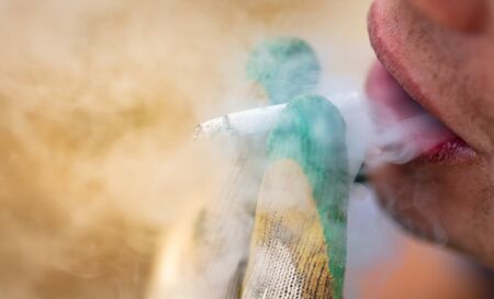A cigarette smokes in the builder's hand. Bad habitの写真素材