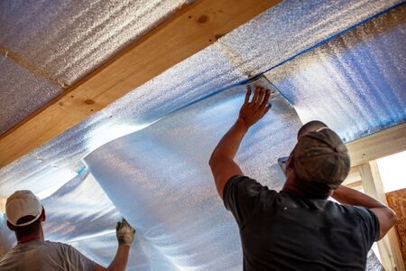 Work insulates the ceiling in the room. Building a house.