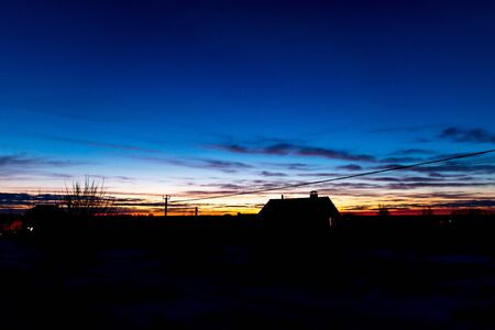Dawn of the sun against a blue sky in a cottage village.の写真素材