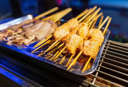 Chicken on wooden sticks for grilling. A dish of Chinese cuisine.の写真素材
