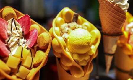 Sweet ice cream with fruits and berries on the counter.