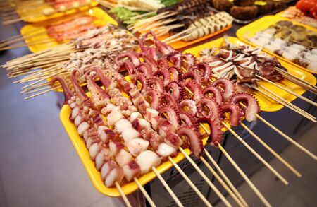Seafood on wooden sticks for grilling. A dish of Chinese cuisine.の写真素材