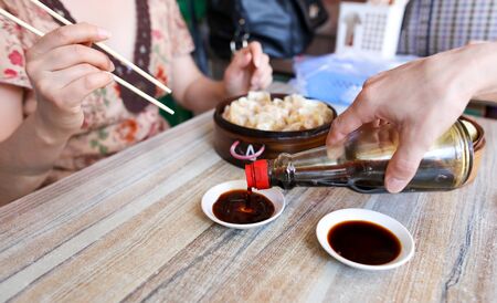 People eat Chinese manti with soy in a cafe.の写真素材