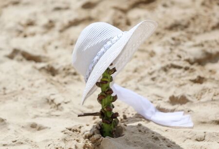 White hat in the sand on the shore of the sea beach.の写真素材