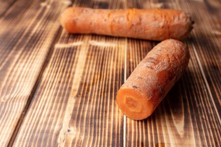 Boiled carrots lies on a wooden background. Red root vegetablesの写真素材