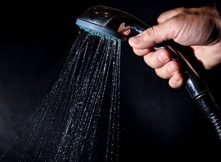 Splashes and drops of water from the shower are isolated on a black background.