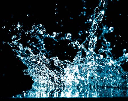 Splashes and drops of blue water on a black background.の写真素材