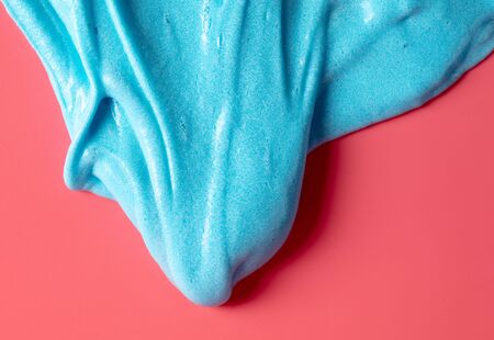 Blue slime isolated on pink background. Jelly-like material for children to playの写真素材