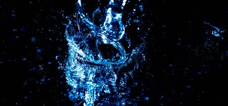 Splashes and drops of blue water on a black background.