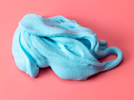 Blue slime isolated on pink background. Jelly-like material for children to play