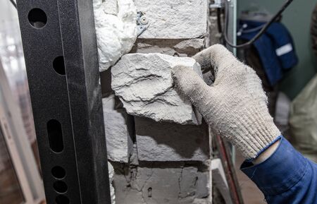 Hands of a worker repairs bricks. Repair the walls in the room.の写真素材