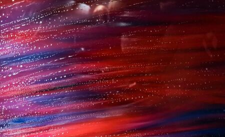 Auto glass in foam and water at a car wash as a backdrop. Texture