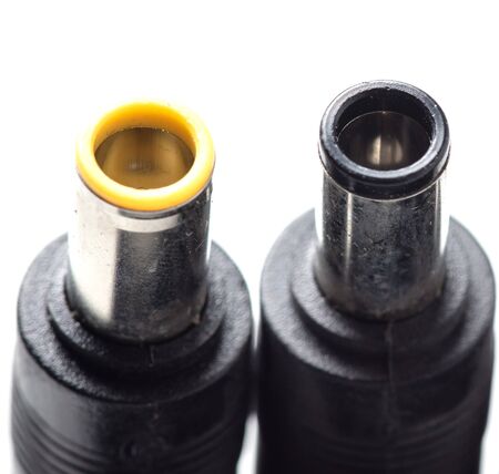 Plugs for charging a laptop on a white background. Macro