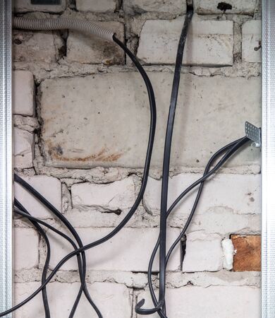 The worker lays an electric wire. Repair the wall in the room.の写真素材