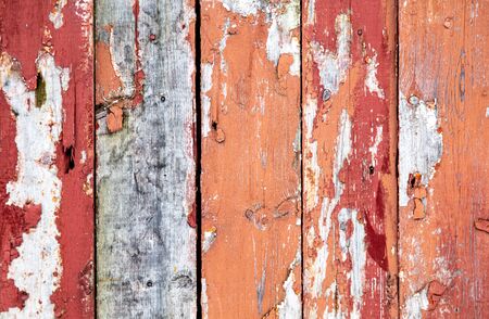 Wooden boards on an old red fence as an abstract background. Texture.