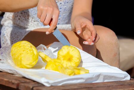 Knife sliced pineapple on a table. Fruit in the tropics.の写真素材