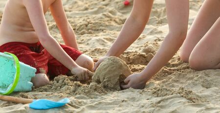 A boy plays in the sand on the beach near the sea. Rest at the resort.の写真素材