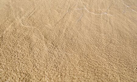 Sand washed with water from the sea. Background