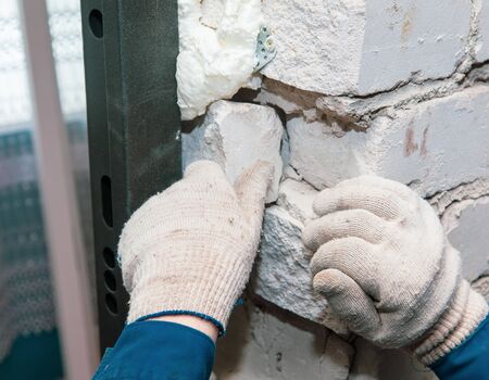 Hands of a worker repairs bricks. Repair the walls in the room.の写真素材