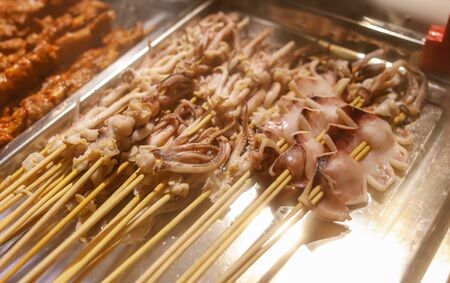 Squid on skewers for frying on the grill. Exotic food.の写真素材