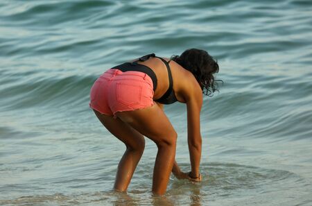 Girl in a swimsuit on the seashore. Rest at the resort.