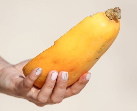 Papaya cut with a knife in the hands. Exotic fruitの写真素材