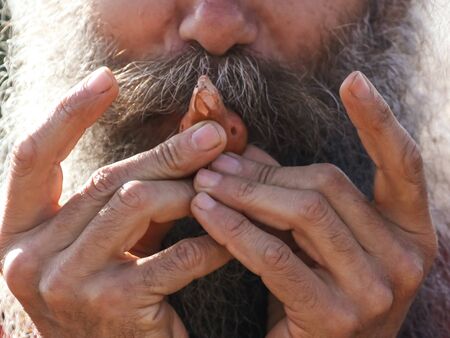 Grandfather plays clay pipe. Musical instrument