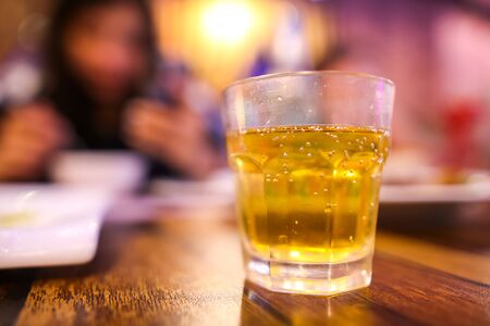 A glass glass with a drink stands on a table in a bar.の写真素材
