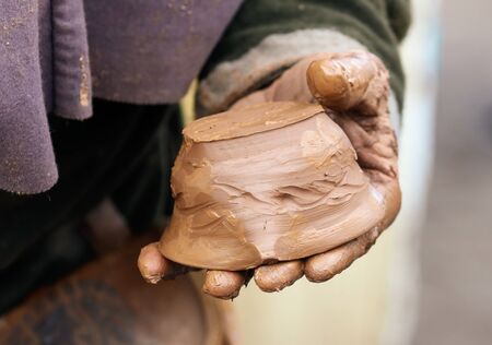 Hands of a man sculpt clay dishes. The ancient method of making dishes.の写真素材