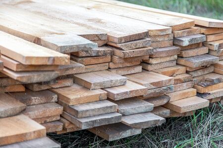 Wooden boards lie on the ground at a construction site at home.