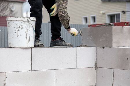 Worker puts foam concrete bricks into the wall. Building a house.