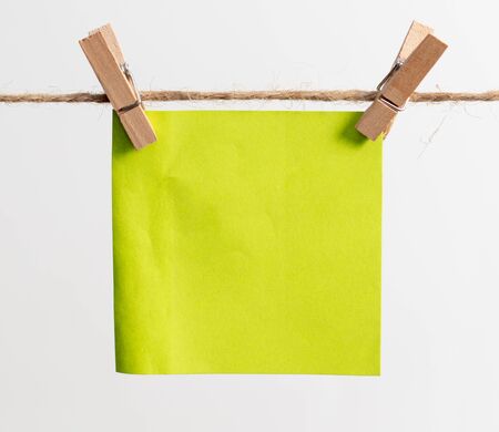 Colored papers hang on a rope on a white background.の写真素材