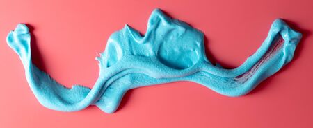 Blue slime isolated on pink background. Jelly-like material for children to playの写真素材