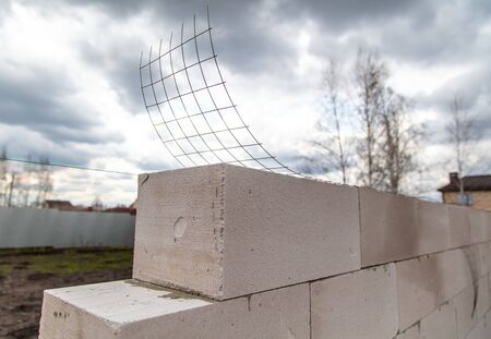 Metal mesh on the wall of foam concrete. Building a house.